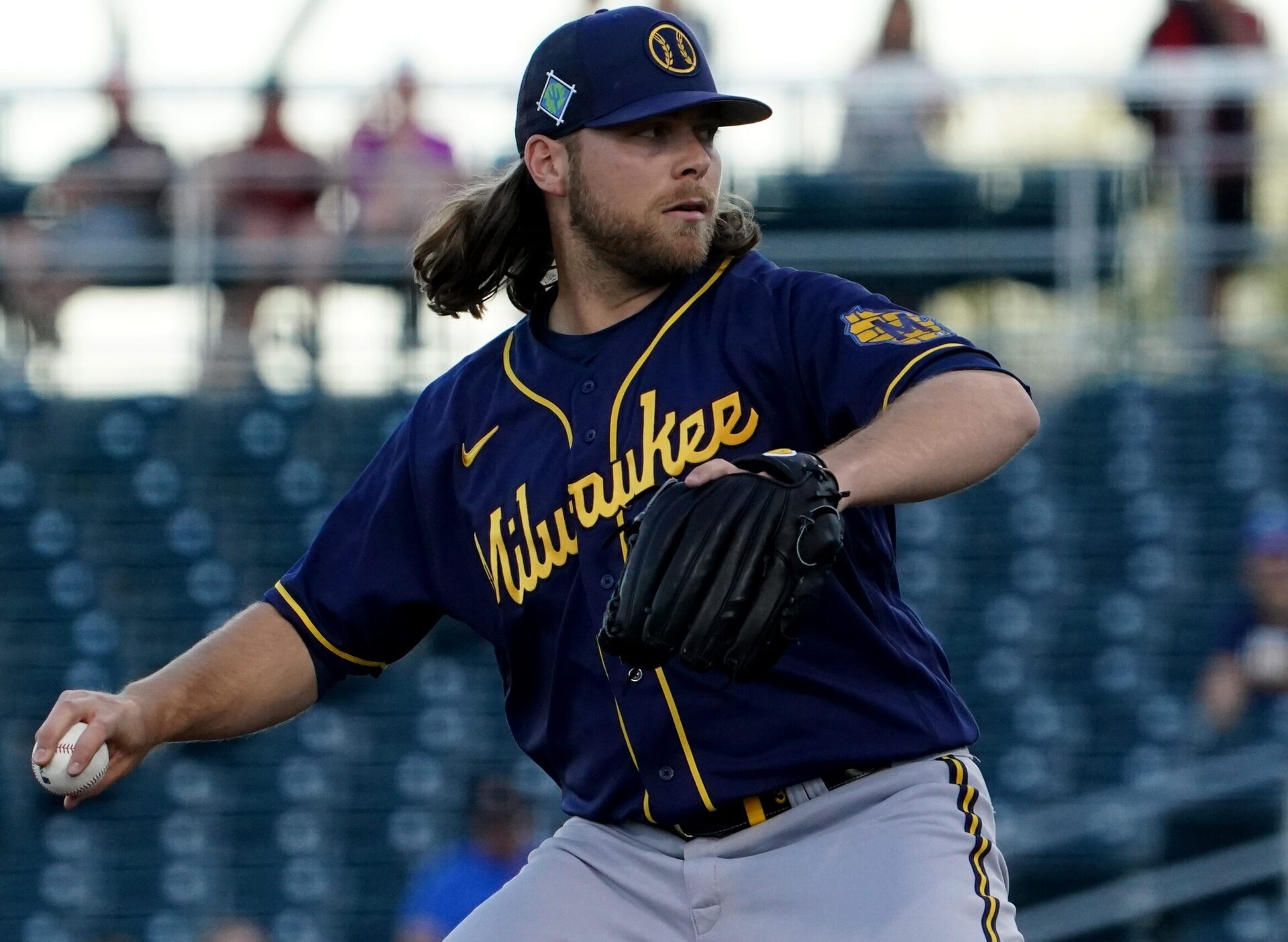 Milwaukee Brewers right-handed pitcher Corbin Burnes reaches back and prepares to deliver a pitch during a spring training game against the Cincinnati Reds