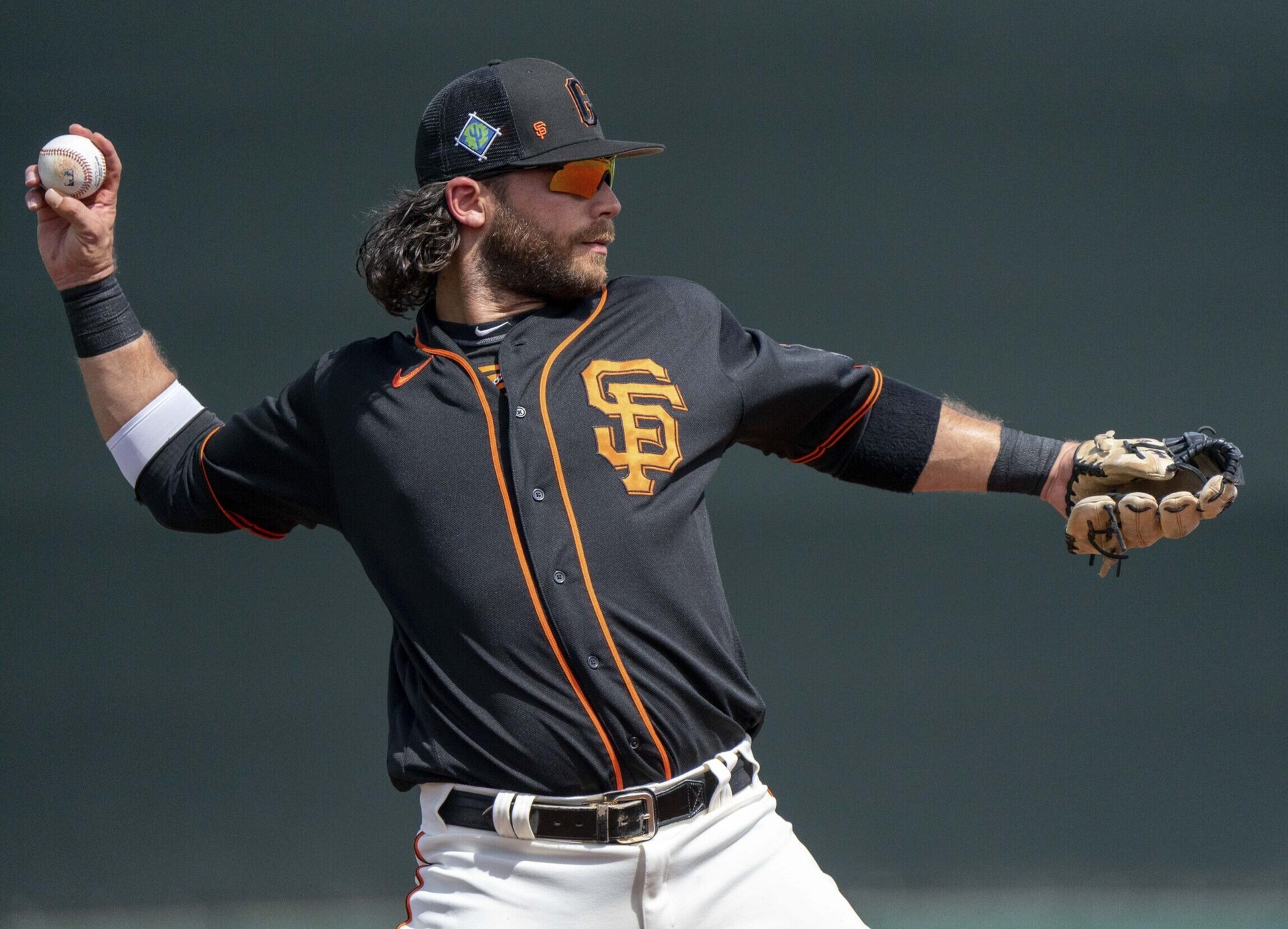 San Francisco Giants shortstop Brandon Crawford prepares to throw the baseball to first base during a spring training game against the Cleveland Guardians