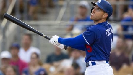 Los Angeles Dodgers first baseman Freddie Freeman follows through on a swing and watches the flight of the baseball after hitting a home run against the San Diego Padres during spring training