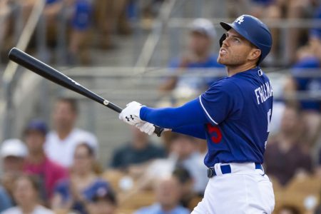 Los Angeles Dodgers first baseman Freddie Freeman follows through on a swing and watches the flight of the baseball after hitting a home run against the San Diego Padres during spring training