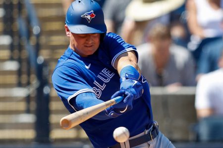 Toronto Blue Jays third baseman Matt Chapman swings at a baseball and gets a base hit in during a spring training game against the New York Yankees