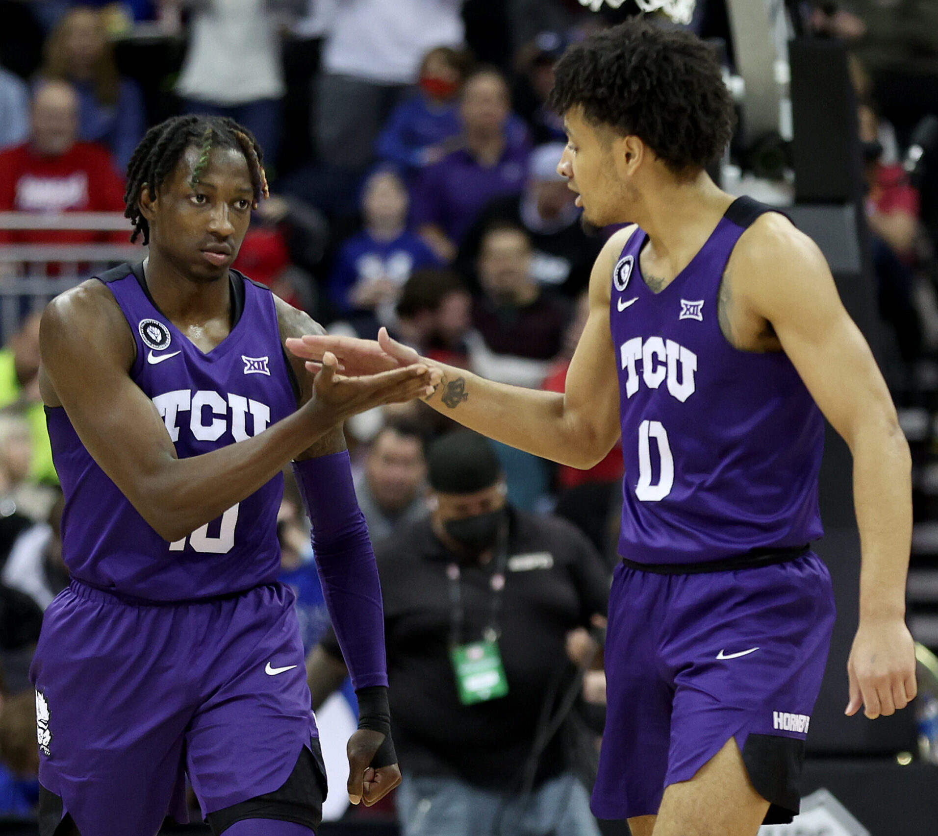 Damion Baugh #10 and Micah Peavy #0 of the TCU Horned Frogs high-five in the second half against the Texas Longhorns during the first round game of the 2022 Phillips 66 Big 12 Men's Basketball Tournament at T-Mobile Center on March 10, 2022 in Kansas City, Missouri