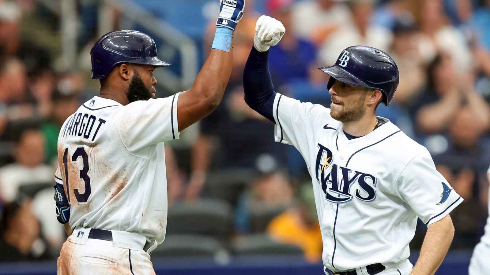 Manuel Margot #13 of the Tampa Bay Rays congratulates Brandon Lowe #8 after his two-run home run against the Oakland Athletics in the seventh inning of a baseball game at Tropicana Field on April 14, 2022 in St. Petersburg, Florida.