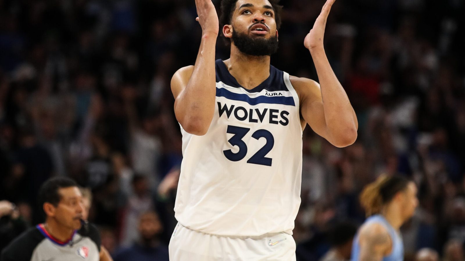 Minnesota Timberwolves center Karl-Anthony Towns extends both hands on each side of his face and breathes a sigh of relief after making a 3-point shot during a first-round NBA playoff game against the Memphis Grizzlies