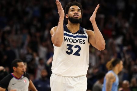Minnesota Timberwolves center Karl-Anthony Towns extends both hands on each side of his face and breathes a sigh of relief after making a 3-point shot during a first-round NBA playoff game against the Memphis Grizzlies