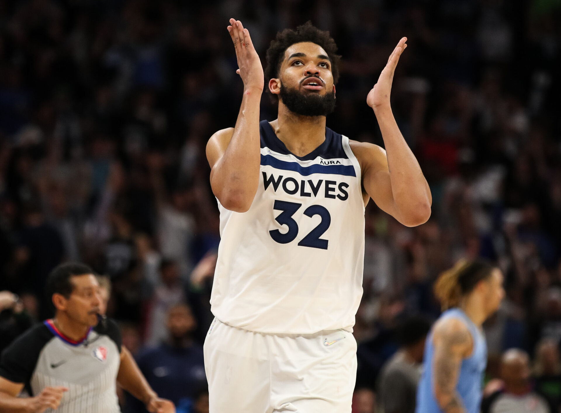 Minnesota Timberwolves center Karl-Anthony Towns extends both hands on each side of his face and breathes a sigh of relief after making a 3-point shot during a first-round NBA playoff game against the Memphis Grizzlies