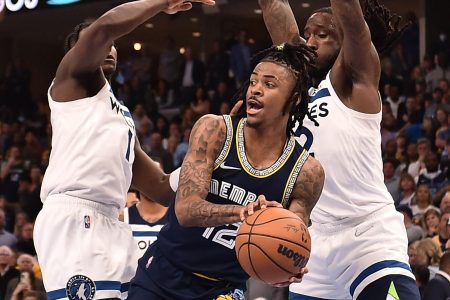 Memphis Grizzlies guard Ja Morant, center, looks to pass around the outstretched arms of the Minnesota Timberwolves' Anthony Edwards, left, and Taurean Prince, right, on Tuesday, April 26, 2022, in Memphis, Tenn.