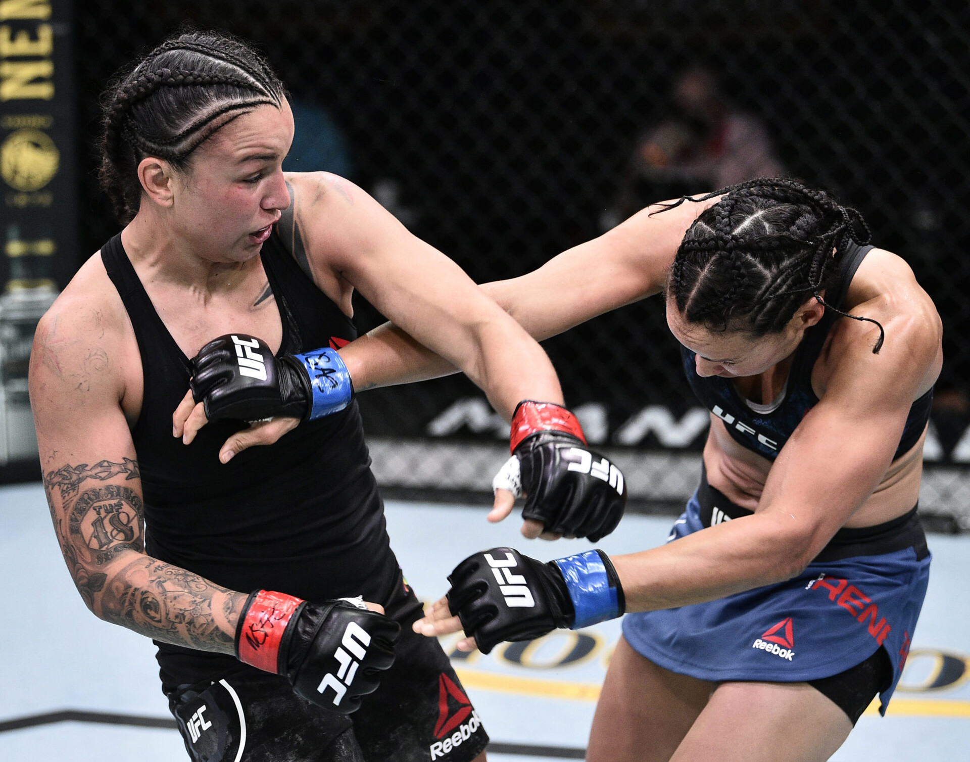 Raquel Pennington, left, punches Marion Reneau, right, in their bantamweight bout during UFC Fight Night at UFC APEX.