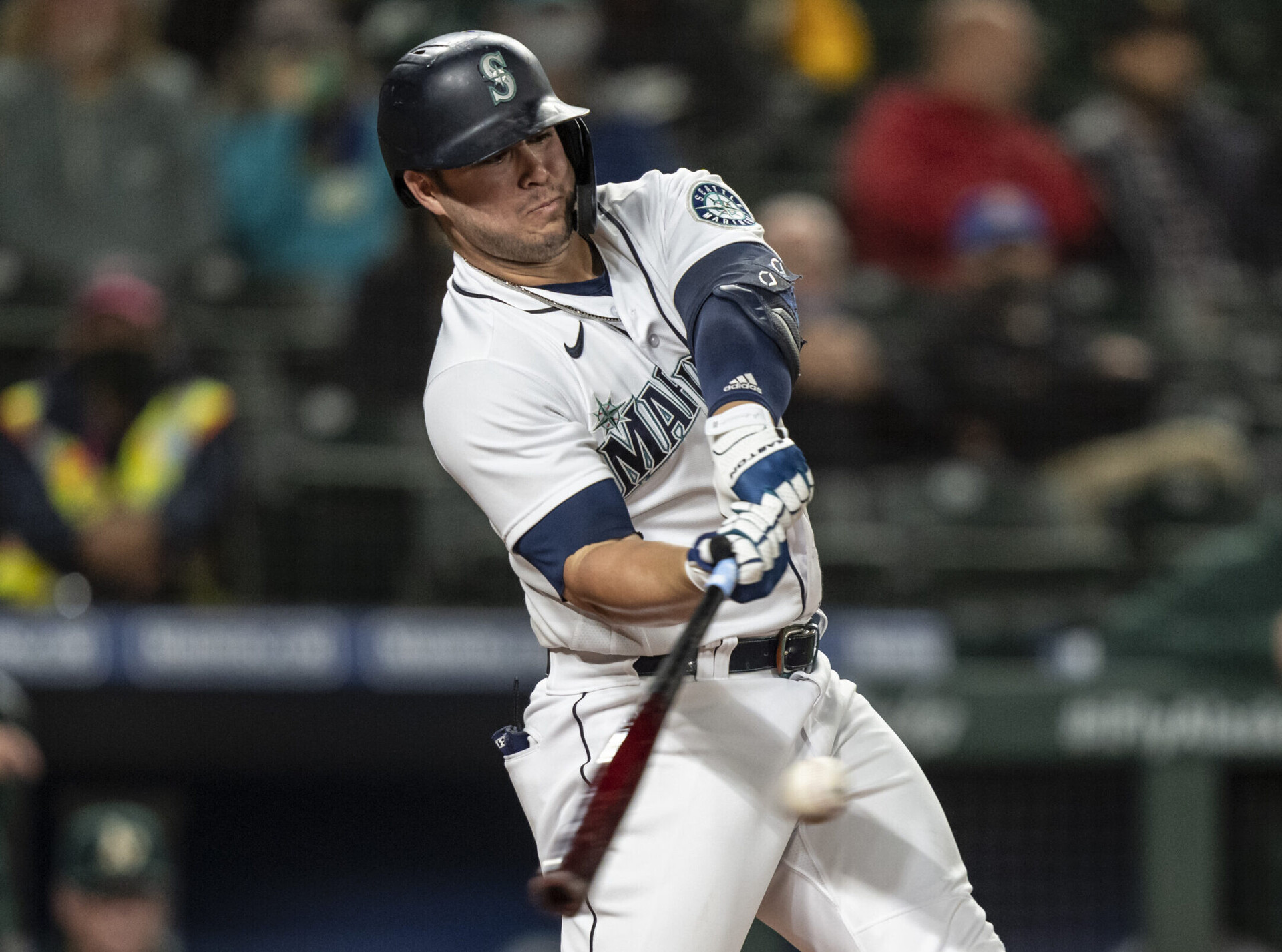 Seattle Mariners first baseman Ty France swings at and connects with a baseball for an RBI double during a game against the Oakland A's