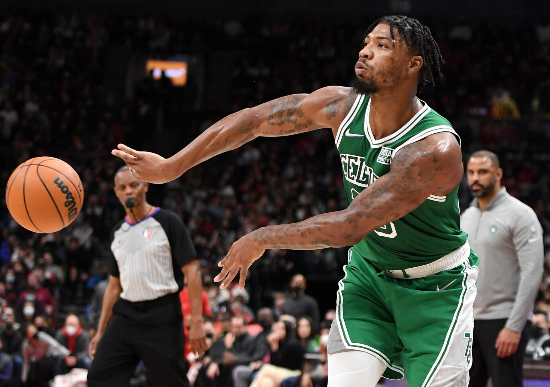 Boston Celtics guard Marcus Smart tosses a no-look pass to an unseen teammate during a game against the Toronto Raptors