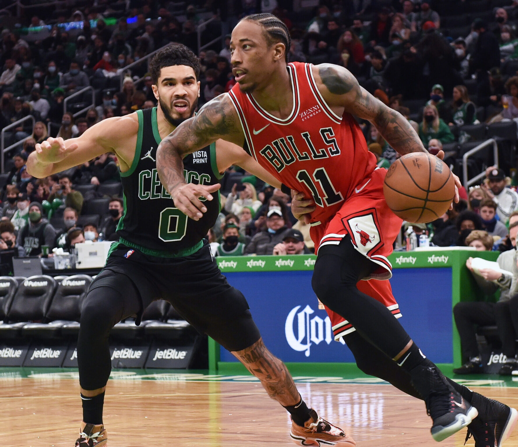 Chicago Bulls forward DeMar DeRozan (left) dribbles the basketball with his left hand as he tries to drive past defending Boston Celtics forward Jayson Tatum (left)