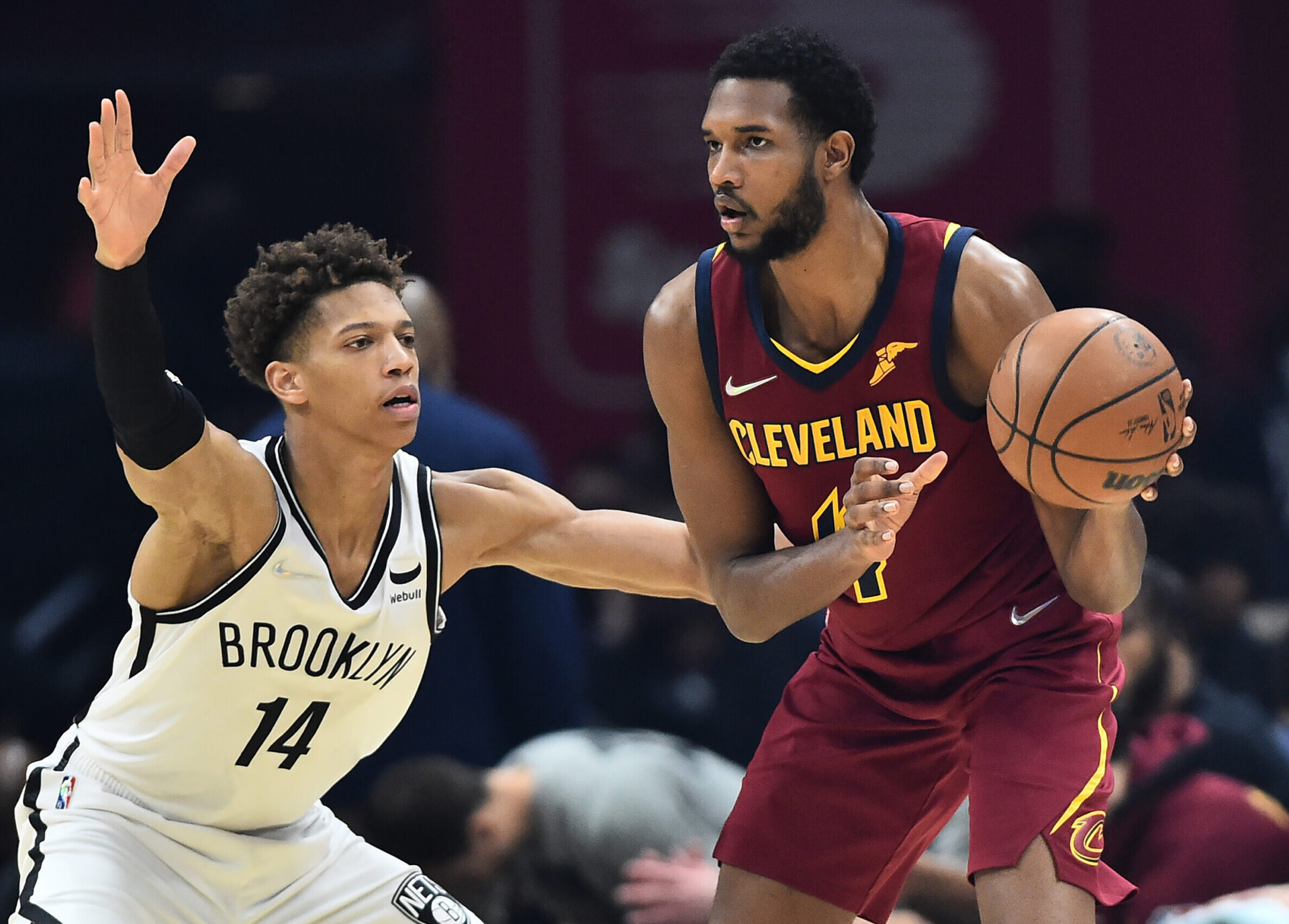 Brooklyn Nets forward Kessler Edwards (left) stretches both arms out and crouches while playing defense as Cleveland Cavaliers forward Evan Mobley (right) dribbles the basketball