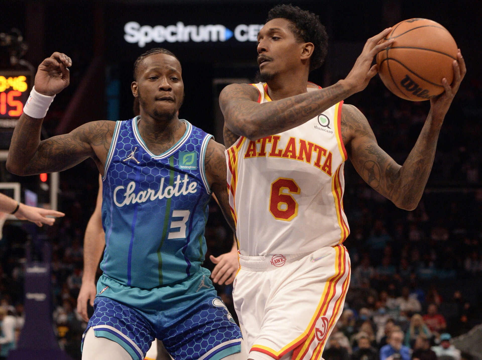 Atlanta Hawks guard Lou Williams (right) controls the basketball with both hands as Charlotte Hornets guard Terry Rozier (left) closely defends