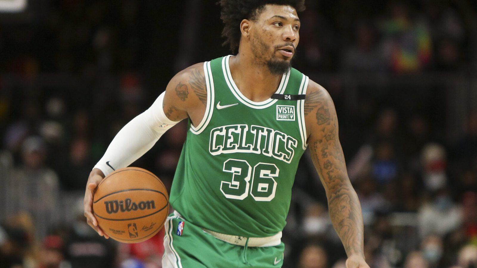 Boston Celtics guard Marcus Smart dribbles the basketball up court with his right hand during a game against the Atlanta Hawks
