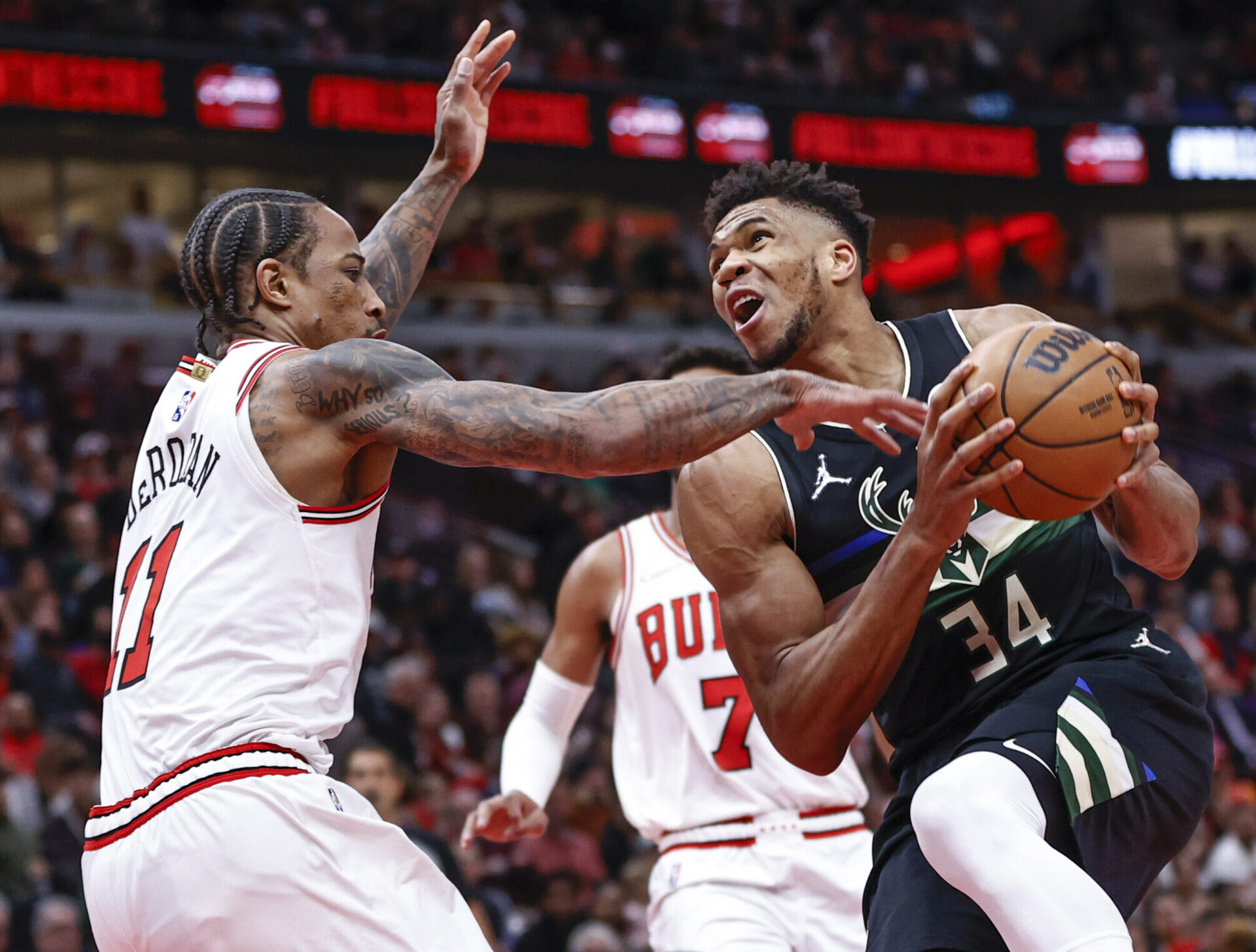 Chicago Bulls forward DeMar DeRozan (right) swipes at the basketball with his right hand as Milwaukee Bucks forward Giannis Antetokounmpo (left) controls it with both hands while preparing to make a move to the basket
