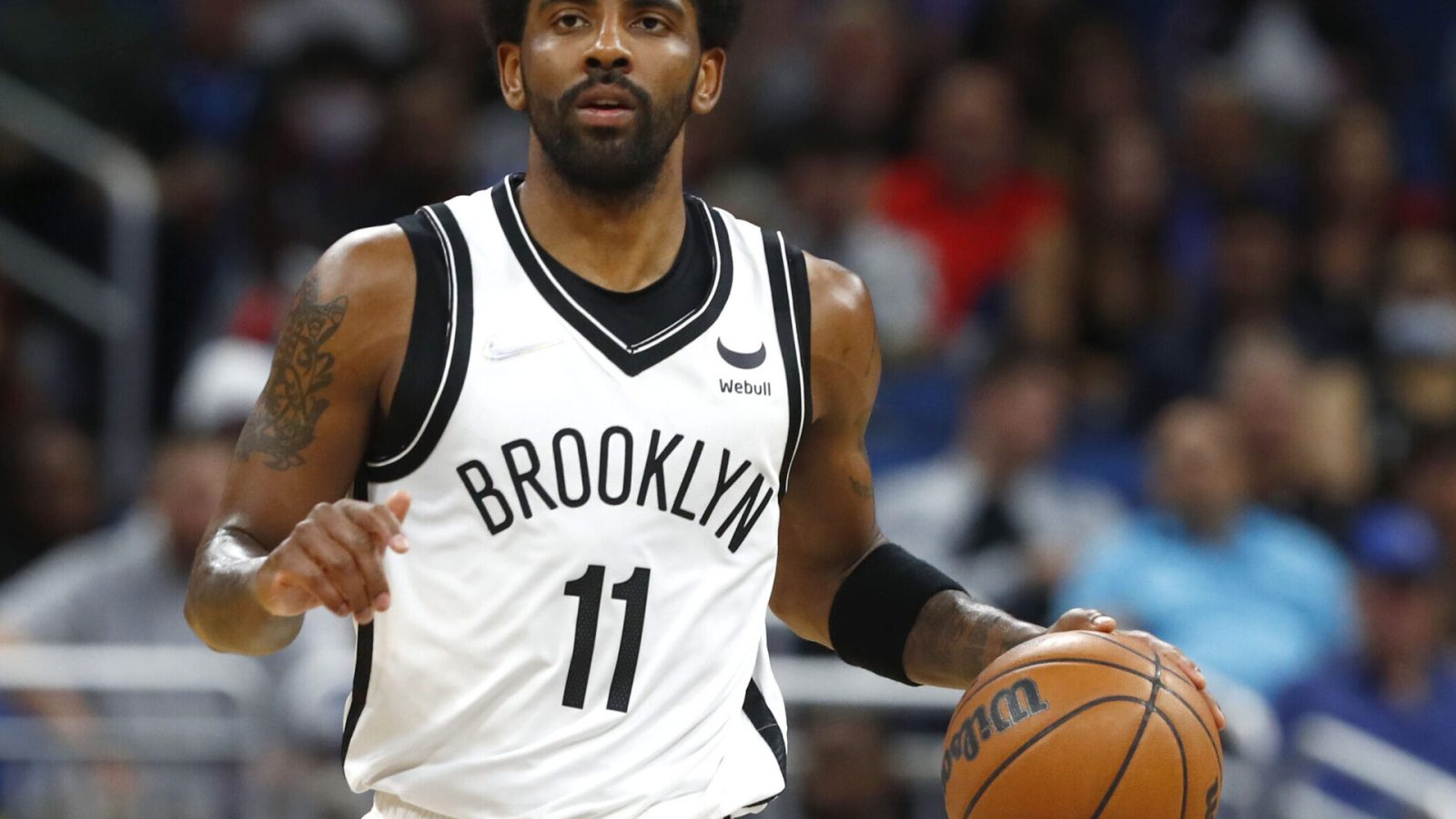 Brooklyn Nets guard Kyrie Irving dribbles the ball up court with his left hand during a game against the Orlando Magic