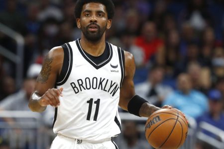 Brooklyn Nets guard Kyrie Irving dribbles the ball up court with his left hand during a game against the Orlando Magic
