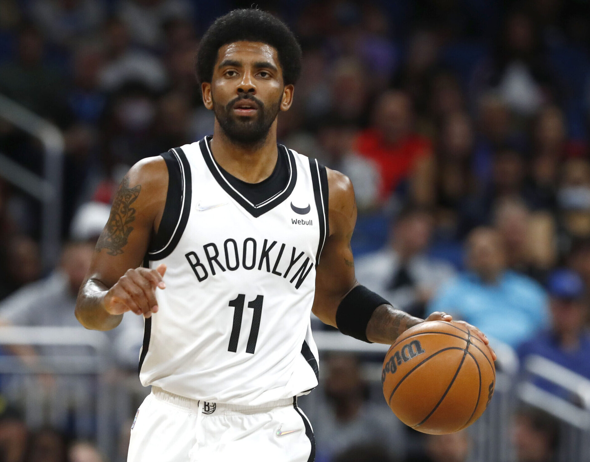 Brooklyn Nets guard Kyrie Irving dribbles the ball up court with his left hand during a game against the Orlando Magic