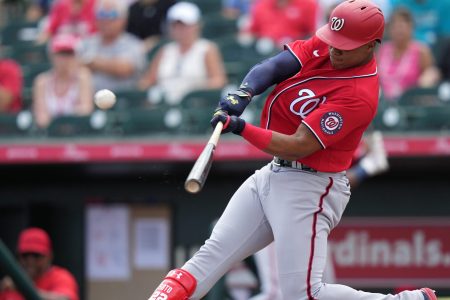 Washington Nationals right fielder Juan Soto swings at an approaching baseball and connects for a solo home run during a spring training game against the Miami Marlins