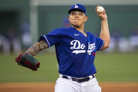 Los Angeles Dodgers left-handed pitcher Julio Urias reaches back and prepares to deliver a pitch against the San Diego Padres during a spring training game