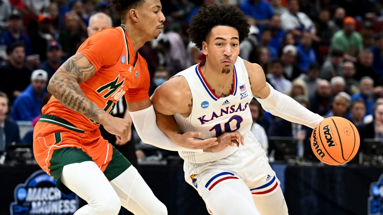 Kansas Jayhawks forward Jalen Wilson (10) drives past Miami Hurricanes guard Jordan Miller (11) during the first half in the finals of the Midwest regional of the men's college basketball NCAA Tournament at United Center in Chicago on Sunday, March 27, 2022.
