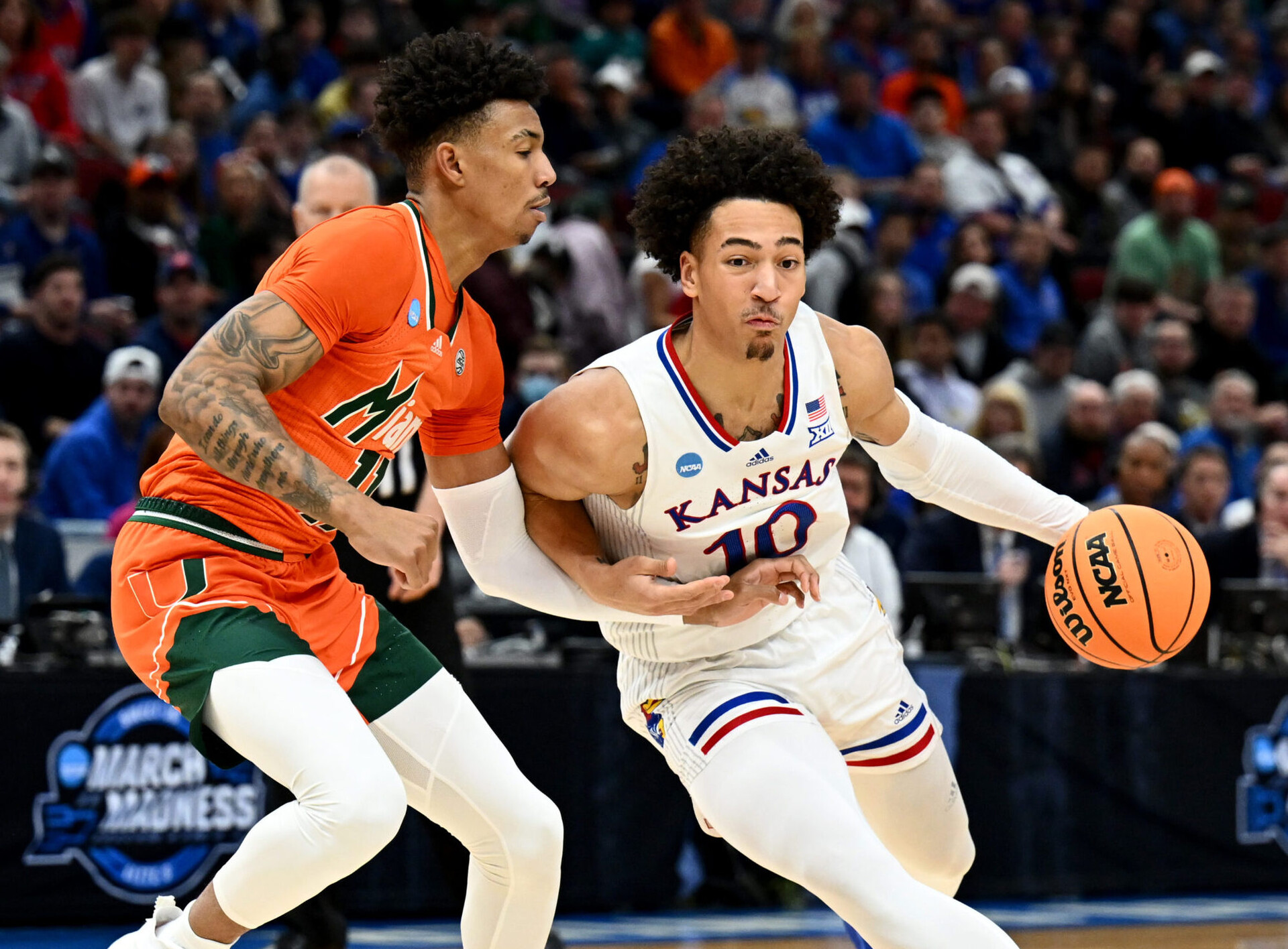 Kansas Jayhawks forward Jalen Wilson (10) drives past Miami Hurricanes guard Jordan Miller (11) during the first half in the finals of the Midwest regional of the men's college basketball NCAA Tournament at United Center in Chicago on Sunday, March 27, 2022.