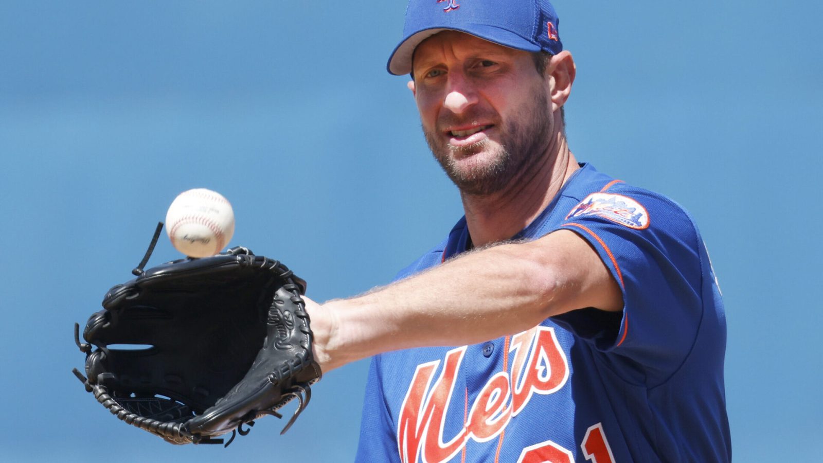 New York Mets starting pitcher Max Scherzer catches the baseball in his glove with his left hand while warming up on the mound before the sixth inning of a spring training game against the St. Louis Cardinals