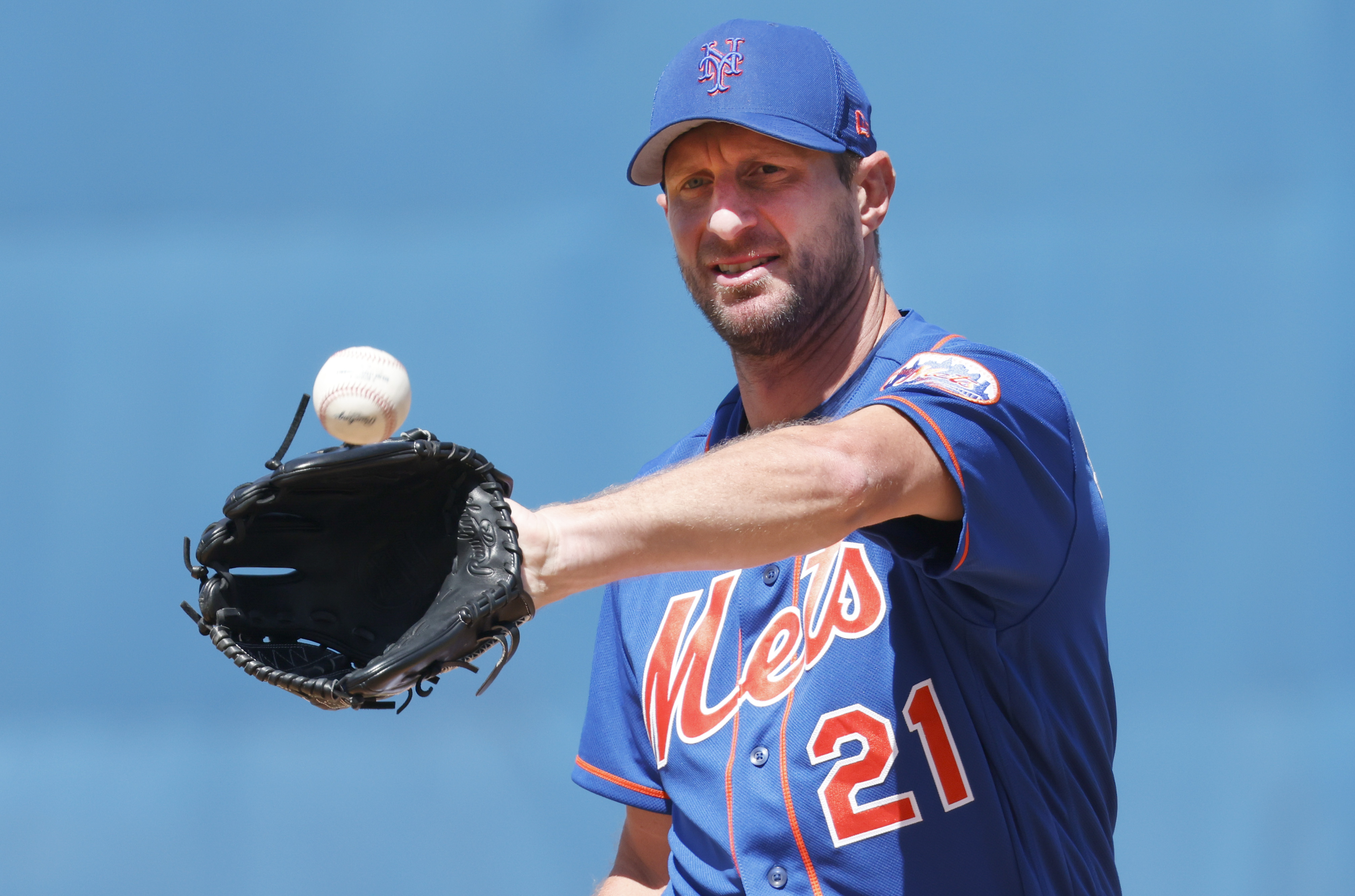 New York Mets starting pitcher Max Scherzer catches the baseball in his glove with his left hand while warming up on the mound before the sixth inning of a spring training game against the St. Louis Cardinals