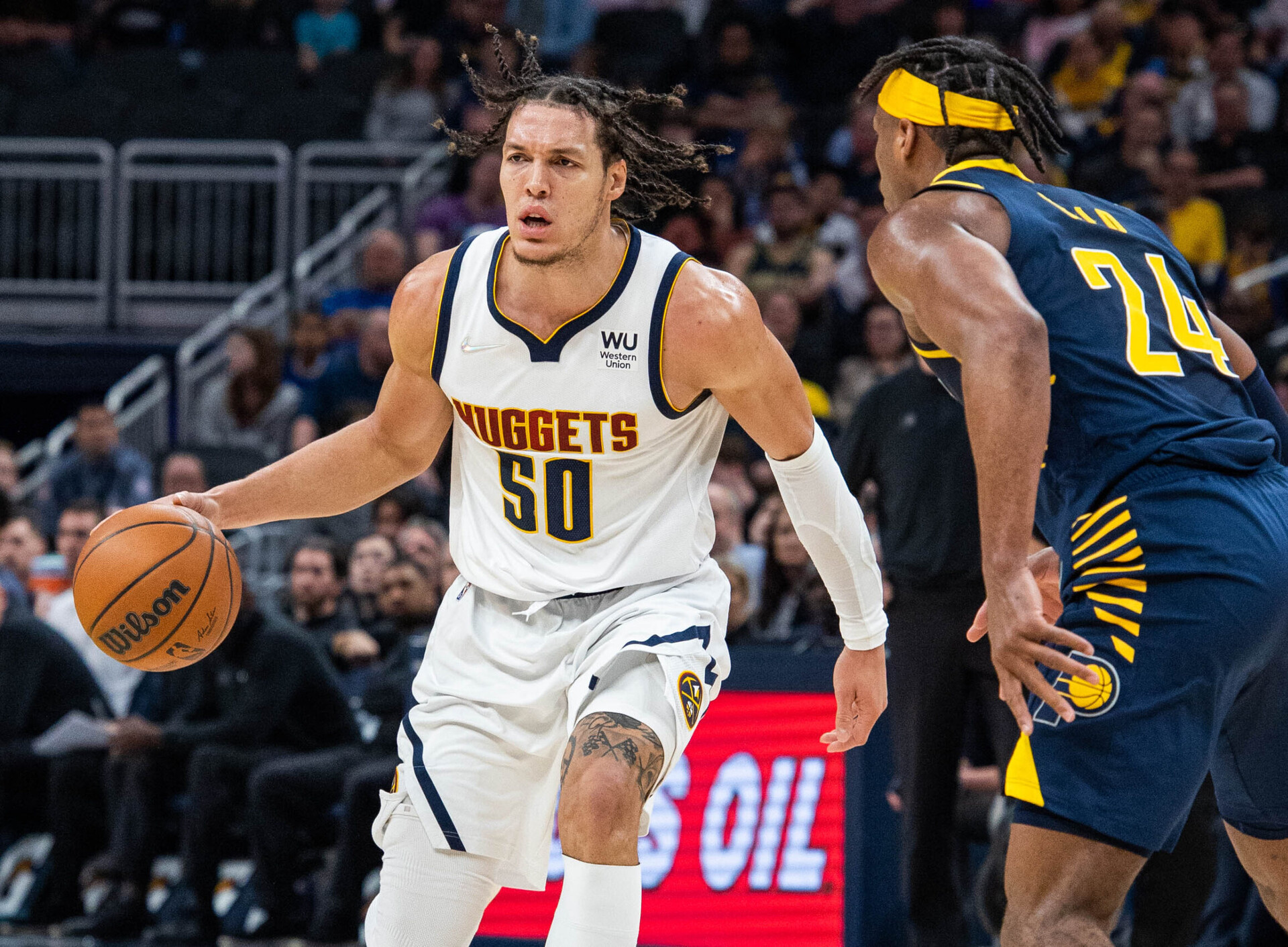 Denver Nuggets forward Aaron Gordon (left) dribbles the ball with his right hand while Indiana Pacers guard Buddy Hield (right) defends