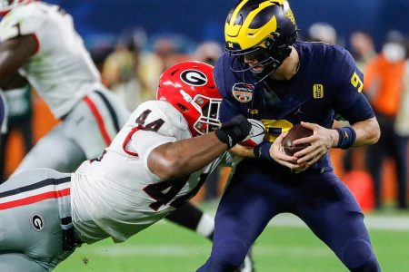 Georgia defensive end Travon Walker, left, brings down Michigan quarterback J.J. McCarthy, right, during the second half of the Orange Bowl at Hard Rock Stadium in Miami Gardens, Florida, on Friday, Dec. 31, 2021.
