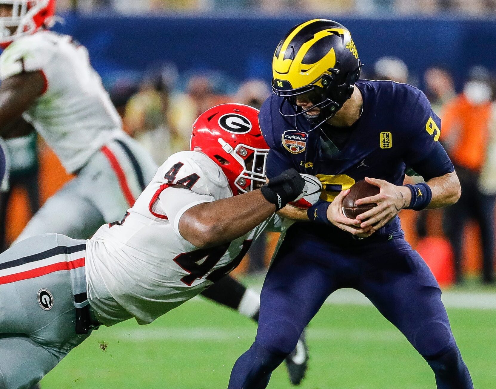 Georgia defensive end Travon Walker, left, brings down Michigan quarterback J.J. McCarthy, right, during the second half of the Orange Bowl at Hard Rock Stadium in Miami Gardens, Florida, on Friday, Dec. 31, 2021.