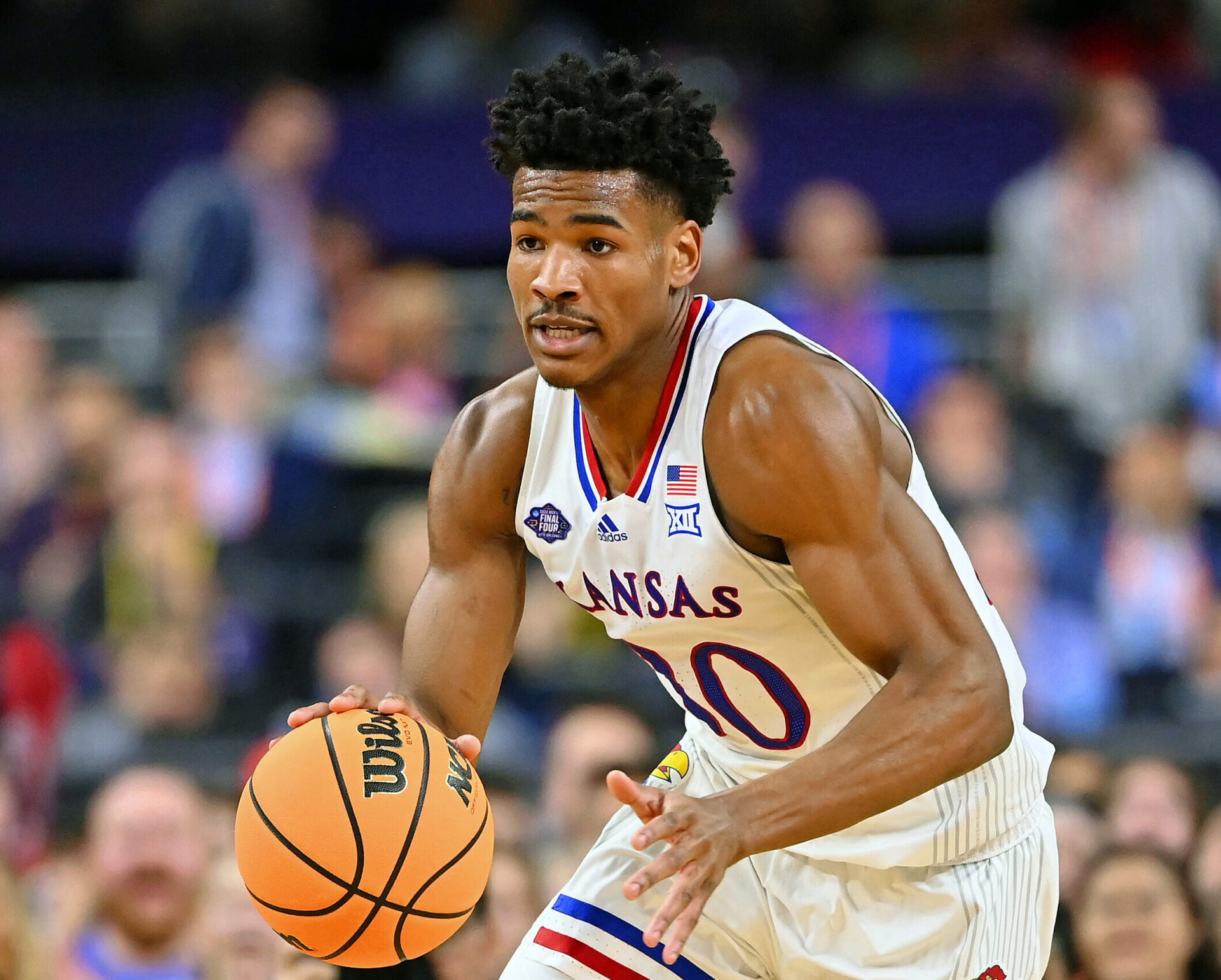 Kansas Jayhawks guard Ochai Agbaji dribbles the ball with his right hand while looking up court against the Villanova Wildcats during the 2022 NCAA men's basketball tournament Final Four semifinals