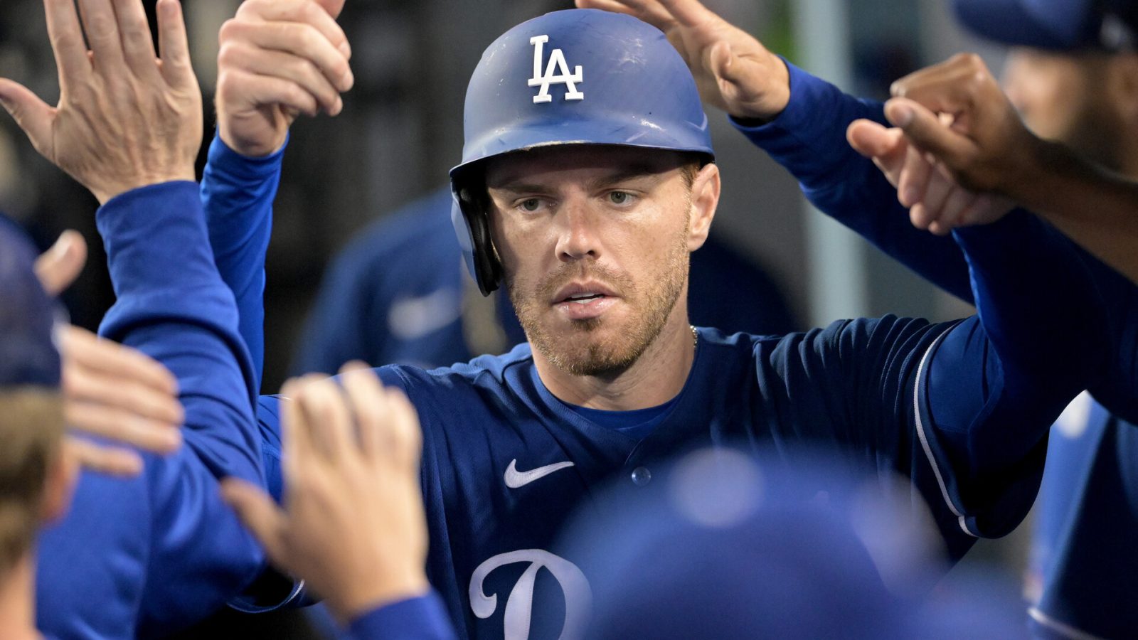 Los Angeles Dodgers first baseman Freddie Freeman (5) is greeted in the dugout after scoring a run in the third inning against the Los Angeles Angels at Dodger Stadium.