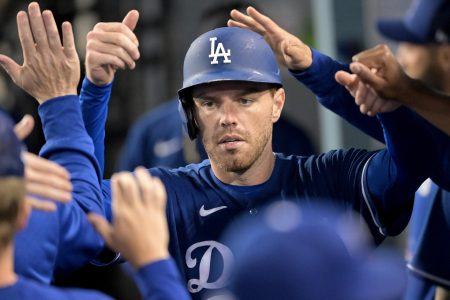 Los Angeles Dodgers first baseman Freddie Freeman (5) is greeted in the dugout after scoring a run in the third inning against the Los Angeles Angels at Dodger Stadium.