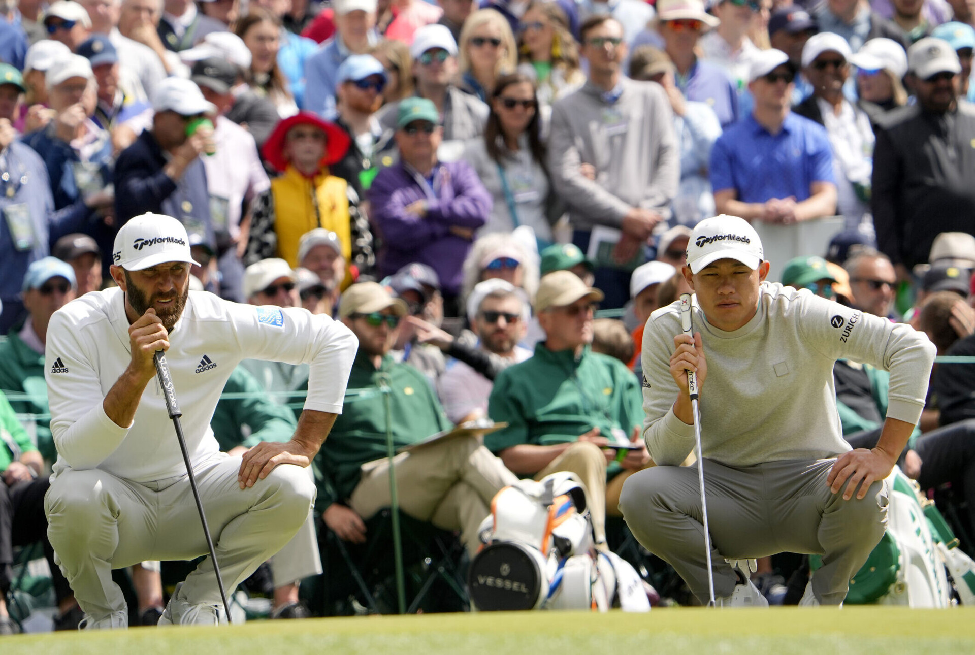 Dustin Johnson, left, and Collin Morikawa, right, line up their putts on no. 6 during the second round of The Masters golf tournament at Augusta National Golf Club on Friday, April 8, 2022.