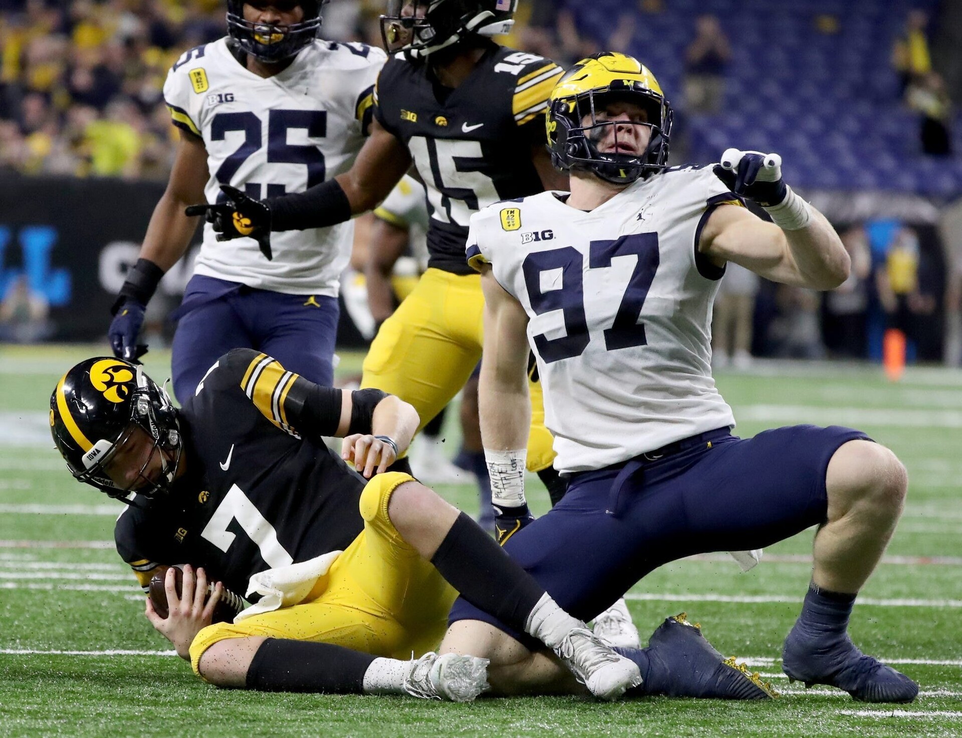 Michigan defensive end Aidan Hutchinson, right, celebrates after a tackle against Iowa during the 2021-22 season.