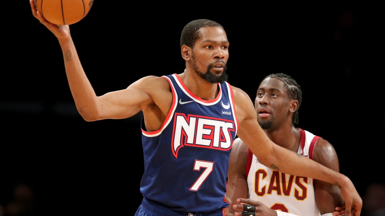 Brooklyn Nets forward Kevin Durant (left) controls the basketball with his outstretched right hand while Cleveland Cavaliers guard Caris LeVert defends
