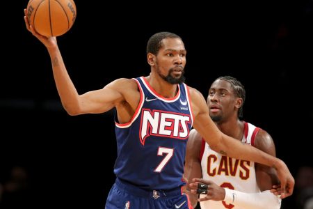 Brooklyn Nets forward Kevin Durant (left) controls the basketball with his outstretched right hand while Cleveland Cavaliers guard Caris LeVert defends