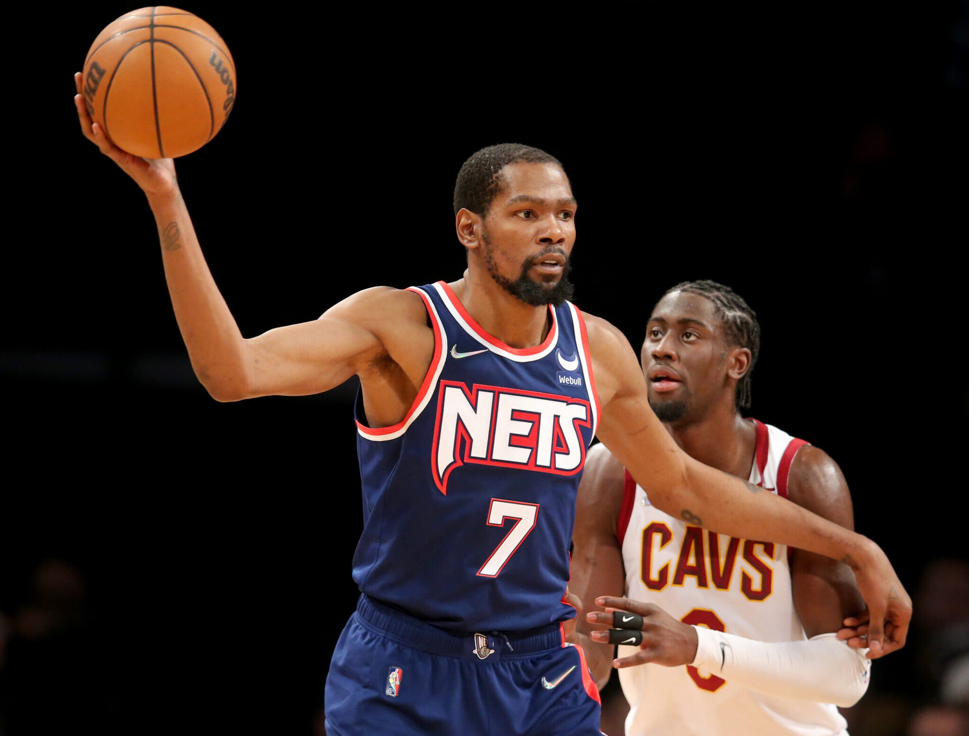 Brooklyn Nets forward Kevin Durant (left) controls the basketball with his outstretched right hand while Cleveland Cavaliers guard Caris LeVert defends