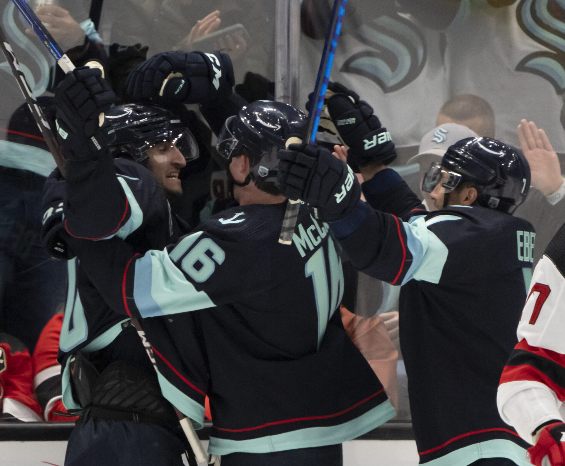 Seattle Kraken forward Matty Beniers (10), left, is congratulated by forward Jared McCann (16) and forward Jordan Eberle (7) after scoring his first NHL goal during the second period against the New Jersey Devils at Climate Pledge Arena in Seattle on Saturday, April 16, 2022.