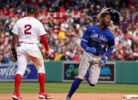 Toronto Blue Jays left fielder Raimel Tapia (right) runs to third base as Boston Red Sox shortstop Xander Boegarts (left, back turned) awaits a relay throw from the outfield