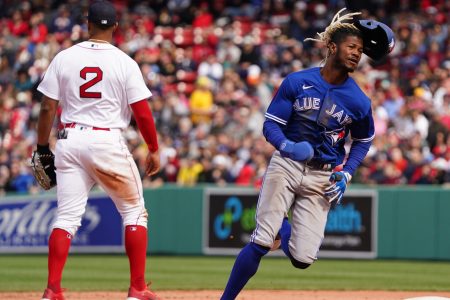 Toronto Blue Jays left fielder Raimel Tapia (right) runs to third base as Boston Red Sox shortstop Xander Boegarts (left, back turned) awaits a relay throw from the outfield