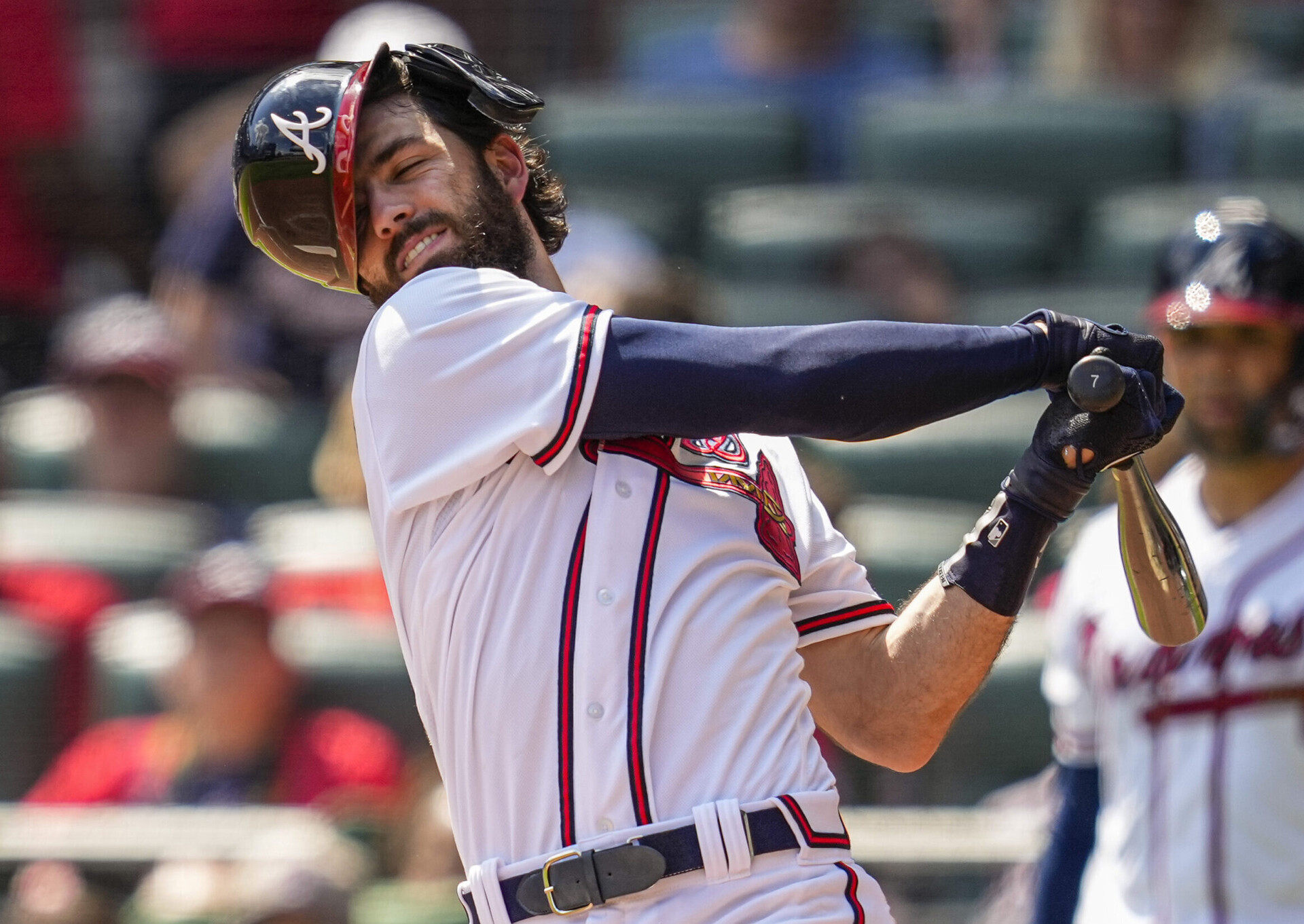 Atlanta Braves shortstop Dansby Swanson loses his helmet swinging at a pitch against the Miami Marlins