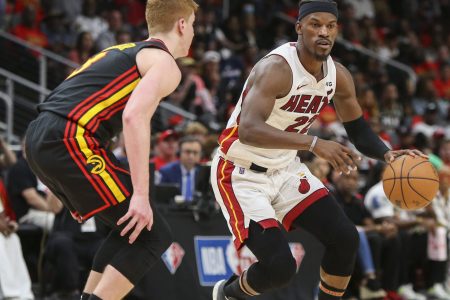Miami Heat forward Jimmy Butler (right) dribbles the basketball with his left hand while Atlanta Hawks guard Kevin Huerter (right) defends during game four of the first round of the 2022 NBA playoffs