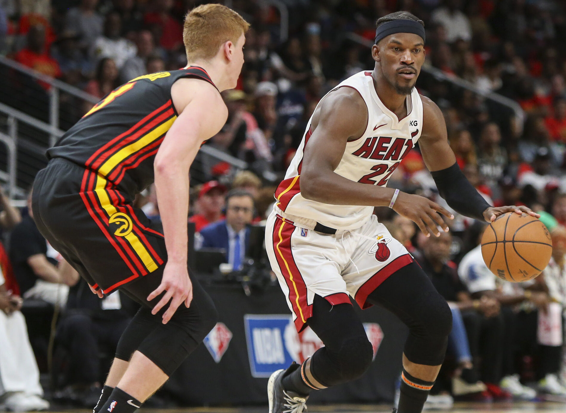 Miami Heat forward Jimmy Butler (right) dribbles the basketball with his left hand while Atlanta Hawks guard Kevin Huerter (right) defends during game four of the first round of the 2022 NBA playoffs