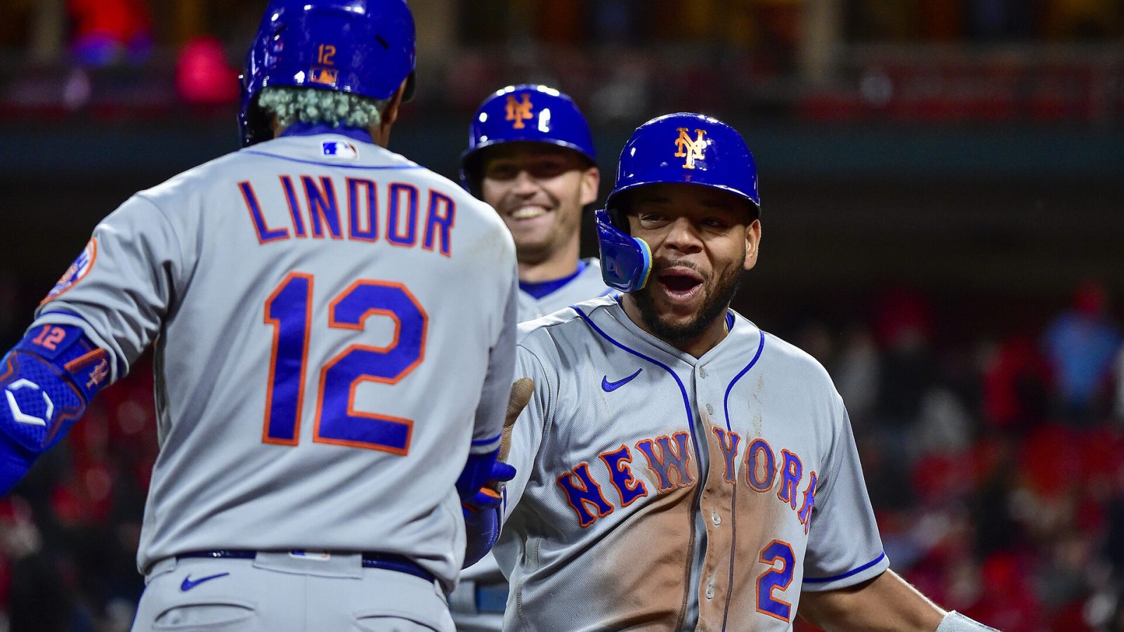 New York Mets shortstop Francisco Lindor (right, back turned) greets smiling pinch hitter Dominic Smith (right) after both runners scored on a single against the St. Louis Cardinals