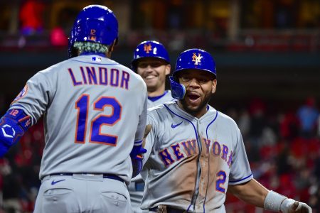 New York Mets shortstop Francisco Lindor (right, back turned) greets smiling pinch hitter Dominic Smith (right) after both runners scored on a single against the St. Louis Cardinals