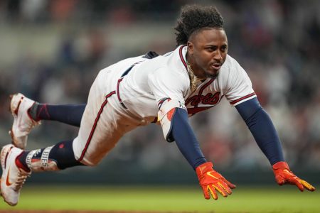 Atlanta Braves second baseman Ozzie Albies dives head-first into third base against the Chicago Cubs