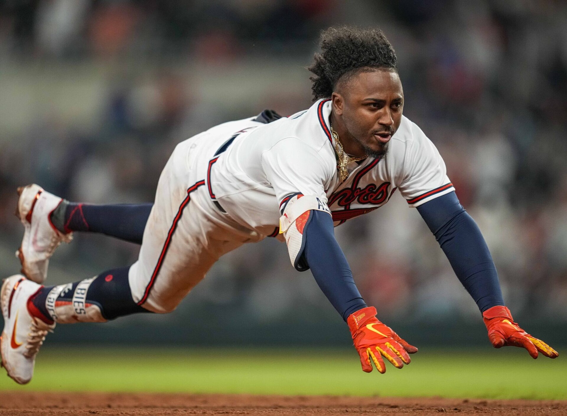 Atlanta Braves second baseman Ozzie Albies dives head-first into third base against the Chicago Cubs