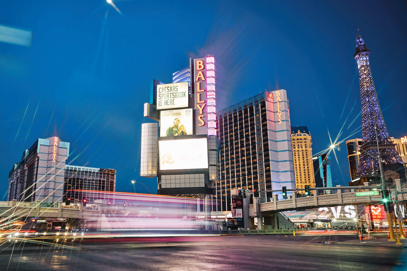 The exterior of Bally's, left, and Paris Las Vegas, right, are seen amid streaks of car headlights on the Las Vegas Strip.